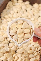 Sliced Blanched Almonds in Spoon Over Wooden Bowl - Healthy Nuts and Baking Ingredients