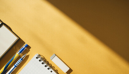 Office Supplies on a Yellow Background Notebook, Pen, Pencil, and Eraser
