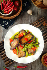 Asian Stir-Fried Eggplant with Peppers and Vegetables on Rustic Wooden Table