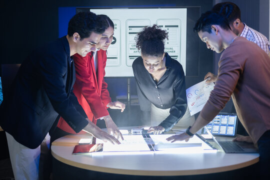 Diverse team of developers and designers having project discussion and strategy meeting. Reviewing digital data, brainstorming UX UI and web design for application development. Startup teamwork