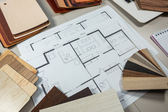 Interior design color palette with house floor plan and wood texture samples on desk