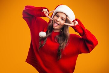 Beautiful santa girl in christmas hat on background