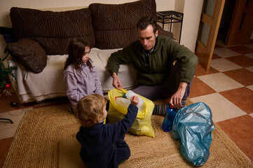 Family Time: Father and Two Kids Packing Toys Into Bags After Christmas Cleanup