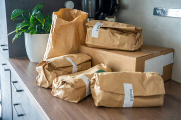 Meal kit ingredients sorted by recipe and placed on the kitchen counter. Concept of convenient grocery delivery for home cooking with pre-portioned ingredients.