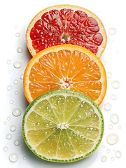 Three citrus slices with water drops: Grapefruit, Orange, Lime