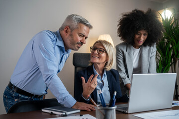Casual meeting of smiling diverse business team analyzing financial data