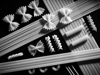 B&W flatlay of various dried pasta.