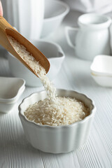 Raw organic rice is poured in white bowl.
