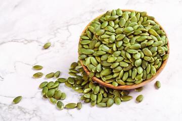 Green Pumpkin Seeds in Wooden Bowl on Marble Table