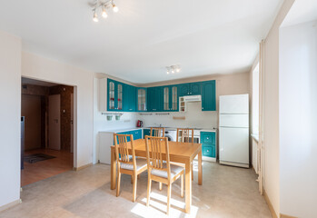 Modern Kitchen and Dining Area with Wooden Furniture and Teal Cabinets
