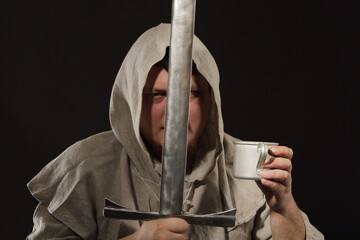 A menacing warrior monk with a sword in one hand and a mug filled with elixir or just moonshine in the other hand