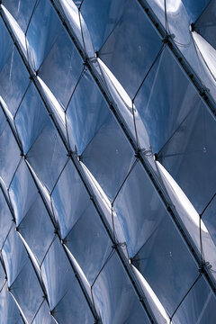 Modern corporate architecture facade glass reflection abstract geometry lines pattern expressing premium business aesthetics through ordered structural design