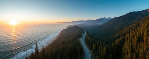 Aerial view of winding coastal highway beside dense evergreen forest. Sun sets over vast Pacific Ocean casting warm light on mountains and sea. Scenic route for exploration and adventure.