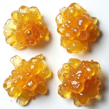 Macro shot presents four cannabis concentrate extracts on white. Golden THC, CBD honey alternatives. Marijuana terpene extracts, medicinal sativa hemp oil alternatives. Relaxing wild plant budder