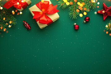 Merry Christmas and Happy Holidays greeting card, frame, border. New Year. Red Christmas ornaments and gifts, presents on green background top view. Xmas holiday festive theme. Christmas decoration
