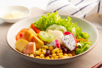 Mixed fruit salad and Grains and vegetable salad in white plate.with mayonnaise salad dressing.