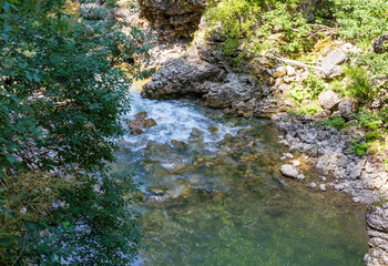 a mountain river with a rapid flow and an unusual stone bed and waterfalls in the summer