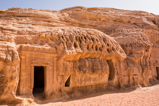 Portal of Nabataean rock cut tombs carved into the mountain face at the Hegra site in Saudi Arabia
