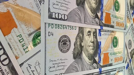 Slow sweeping motion over arranged 100 dollar bills establishing an exclusive investment background where every detail reinforces the concept of money flow and active cash circulation
