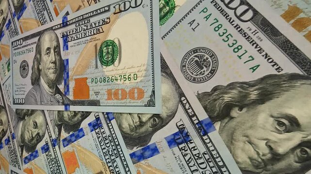 Continuous slide across scattered 100 dollar banknotes forming an exclusive financial business setting that emphasizes investment depth and the vibrant movement of cash and money