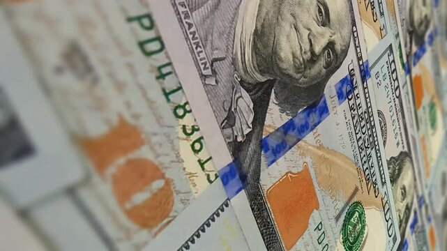 Steady glide over blur enhanced 100 dollar banknotes creating an exclusive investment influenced business background enriched by smooth money flow and subtle dynamic cash effects
