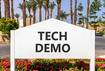Tech demo symbol. Concept word Tech demo on beautiful white billboard. Beautiful blue sky and palm...