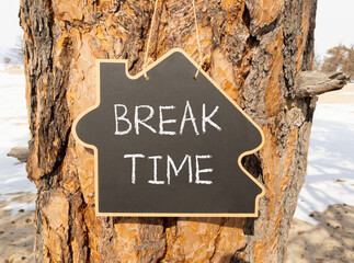 Break time symbol. Concept word Break time on beautiful black blackboard. Beautiful old pine tree background. Black blackboard. Business break time concept. Copy space.