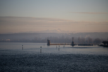 Lake Constance and Constance Harbor with snow-covered S&auml;ntis mountain in the background during a pastel-colored winter evening. Konstanz, Baden-W&uuml;rttemberg, Germany.
