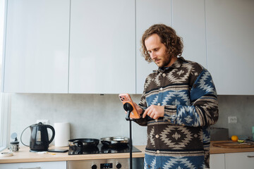 White man home cook checking jar label in cozy kitchen