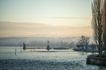 Lake Constance and Constance Harbor with snow-covered S&auml;ntis mountain in the background during a pastel-colored winter evening. Konstanz, Baden-W&uuml;rttemberg, Germany.