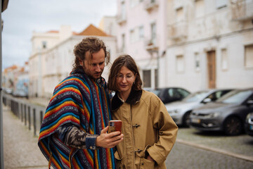 Pair of individuals enjoys viewing vacation snapshots nearby