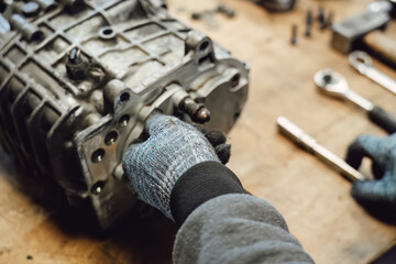 Disassembled old car gearbox with gears in an auto service garage. Repair, maintenance, and replacement of worn mechanical transmission parts in a vehicle