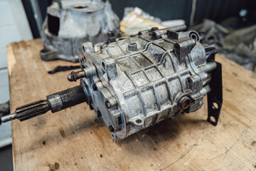 Disassembled old car gearbox with gears in an auto service garage. Repair, maintenance, and replacement of worn mechanical transmission parts in a vehicle