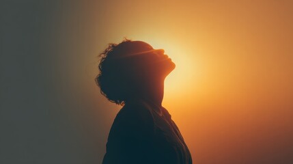 Peaceful contemplation in silhouette against a warm sunset glow