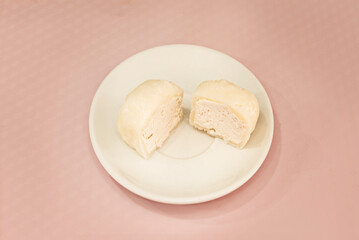 Tricolor mochi (white, pink, and green) filled with smooth anko, representing the colors of the Japanese flag, presented on a ceramic plate with floral motifs
