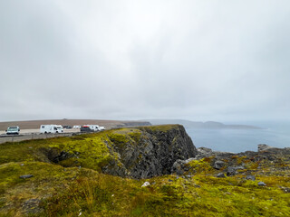 The north cape globe monument perched on a cliff with a misty sea view in norway