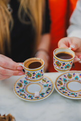 hands of girls holding cups of turkish coffee