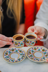 hands of girls holding cups of turkish coffee