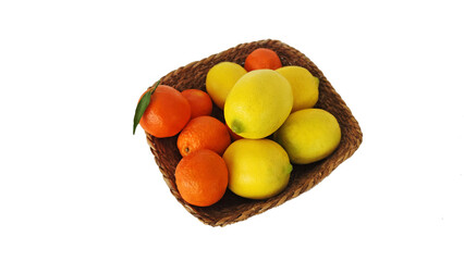 Bright  and freshly picked yellow lemons and vibrant King mandarins, some with green leaves in a rustic woven basket as food background isolated on white  