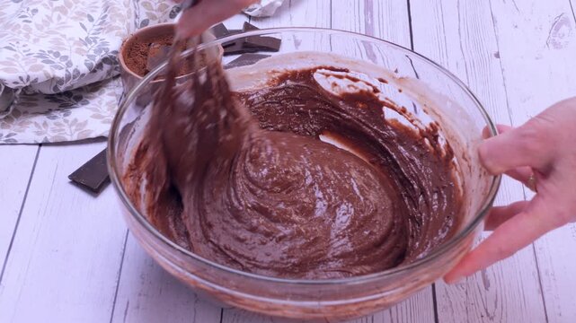 Close-up of mixing brownie batter in a bowl, showing the smooth and rich chocolate preparation process. 4k