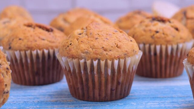 Freshly baked banana chocolate muffins placed on a table, showing warm texture and chocolate details. Ideal for food content, recipe videos, bakery promotions and culinary projects.