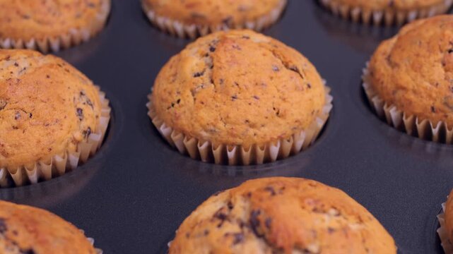 Freshly baked banana chocolate muffins taken out of the oven. Homemade, delicious and comforting feel of the dessert. Perfect for culinary projects, recipe videos, bakery promotions, food blogs 