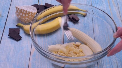 Ripe bananas being mashed with a fork in a glass bowl. Smooth, natural food preparation process for cooking tutorials, recipe videos, baby food, healthy eating content and kitchen demonstrations. 4k
