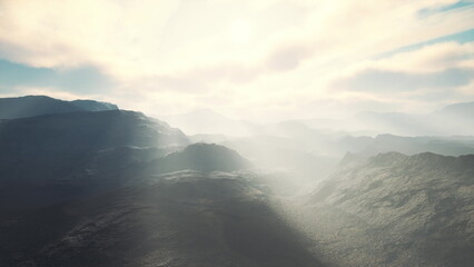 Early morning light filters through the misty mountains, illuminating the rugged terrain below. A sense of tranquility envelops the landscape, inviting exploration and reflection.