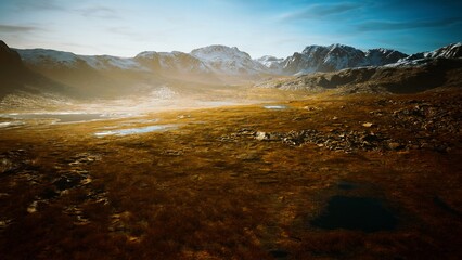Golden sunlight illuminates a sprawling landscape of rolling hills and majestic peaks. Still lakes reflect the vibrant colors of nature, creating a peaceful and harmonious atmosphere.