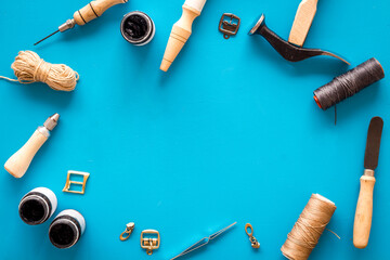 Frame flat lay of leather craftsman or shoemaker tools and equipment, top view