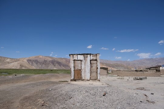 View of high-altitude Bulunkul village with building on toilet, surroundings with mountain background, near Bulunkul and Yashilkul lakes, Pamir Highway in Gorno-Badakshan, Tajikistan