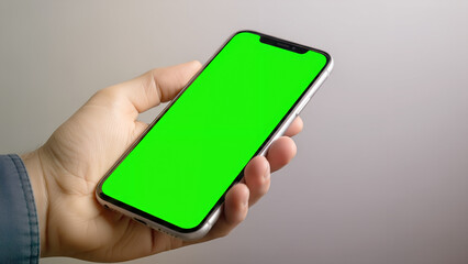 Hand Holding Smartphone with Blank Green Screen Mockup Isolated on Clean Gray Background