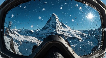Ski goggles frame a breathtaking view of majestic snow-capped mountains under a clear blue sky, with a bright sun and snowflakes on the wet lens surface.