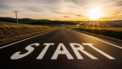 Open road with the word start painted on the asphalt leading toward a bright sunrise symbolizing new beginnings, motivation, opportunity, and forward progress
